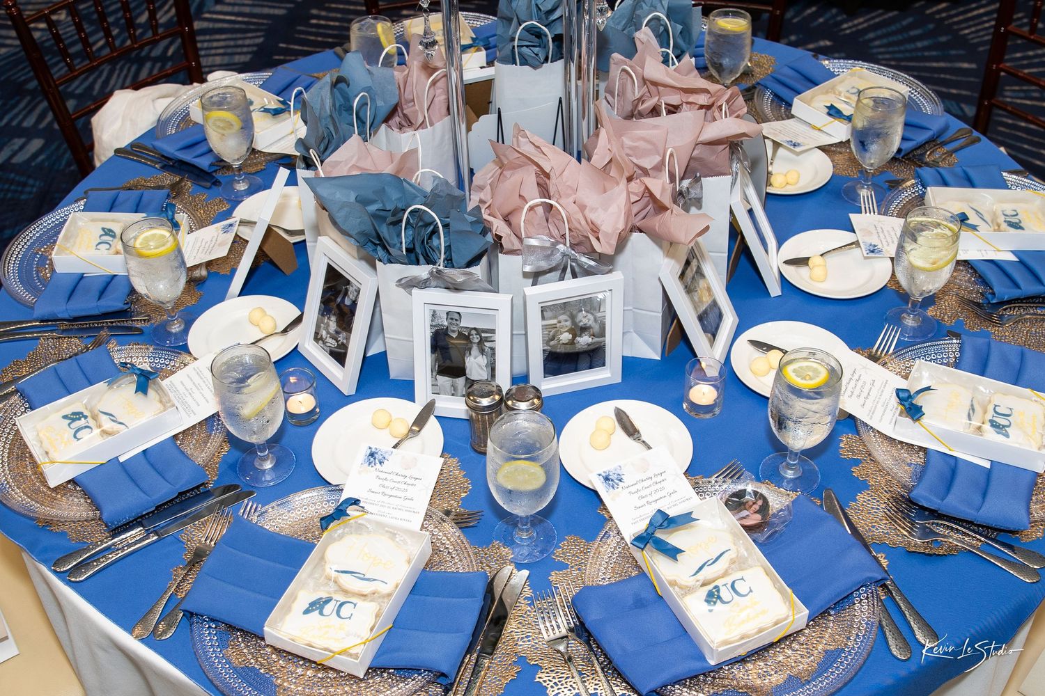 Elegant wedding reception table setting with blue and white decor featuring silver candle holders and place settings.