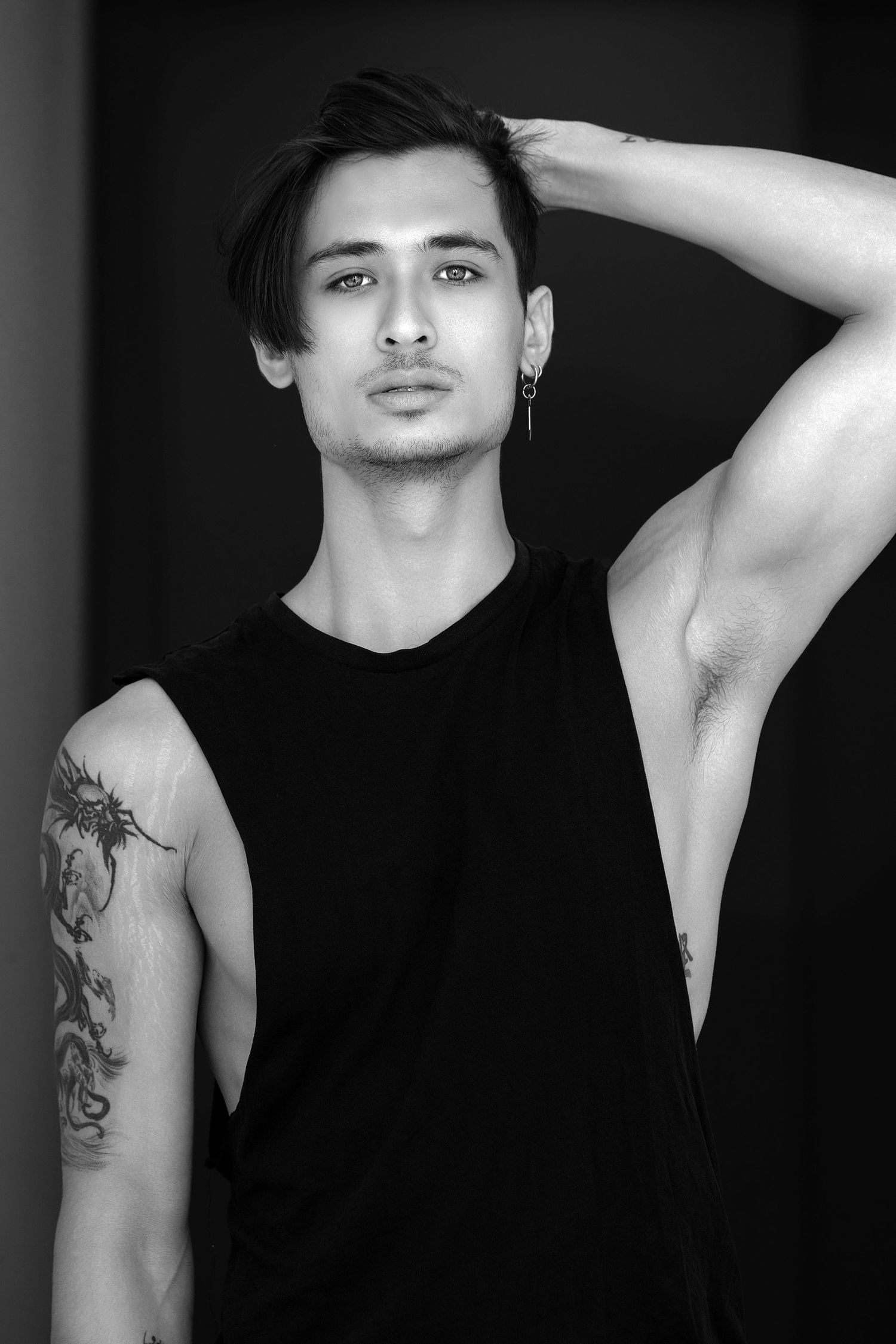 Black and white artistic portrait series showing dramatic poses and tattoo art in moody lighting.