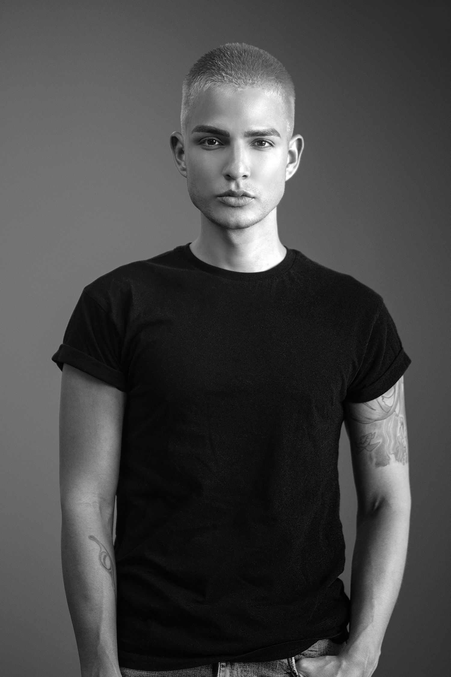 Black and white portrait series showing person in black t-shirt against gray background from different angles.