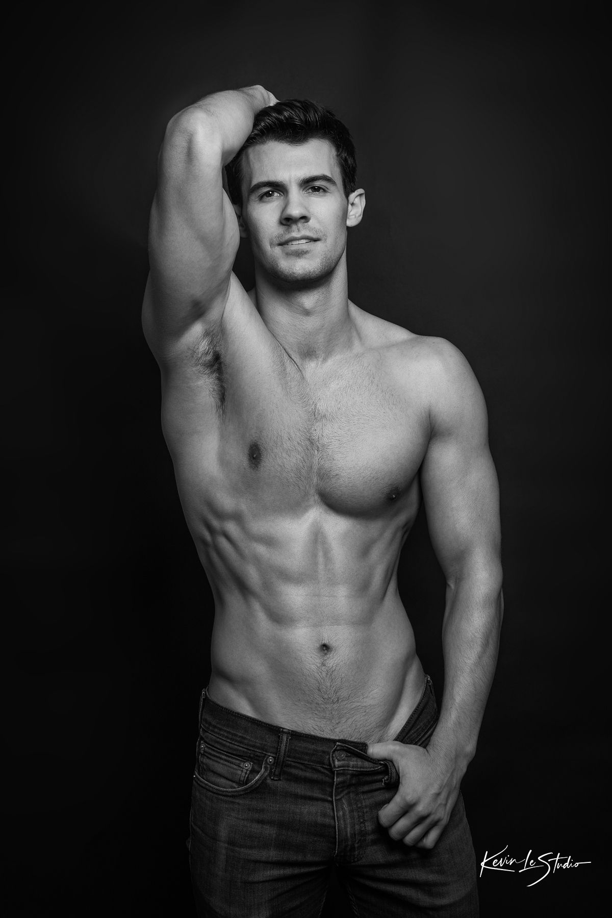 Black and white artistic portraits showing muscular male torso in denim jeans against dark background.