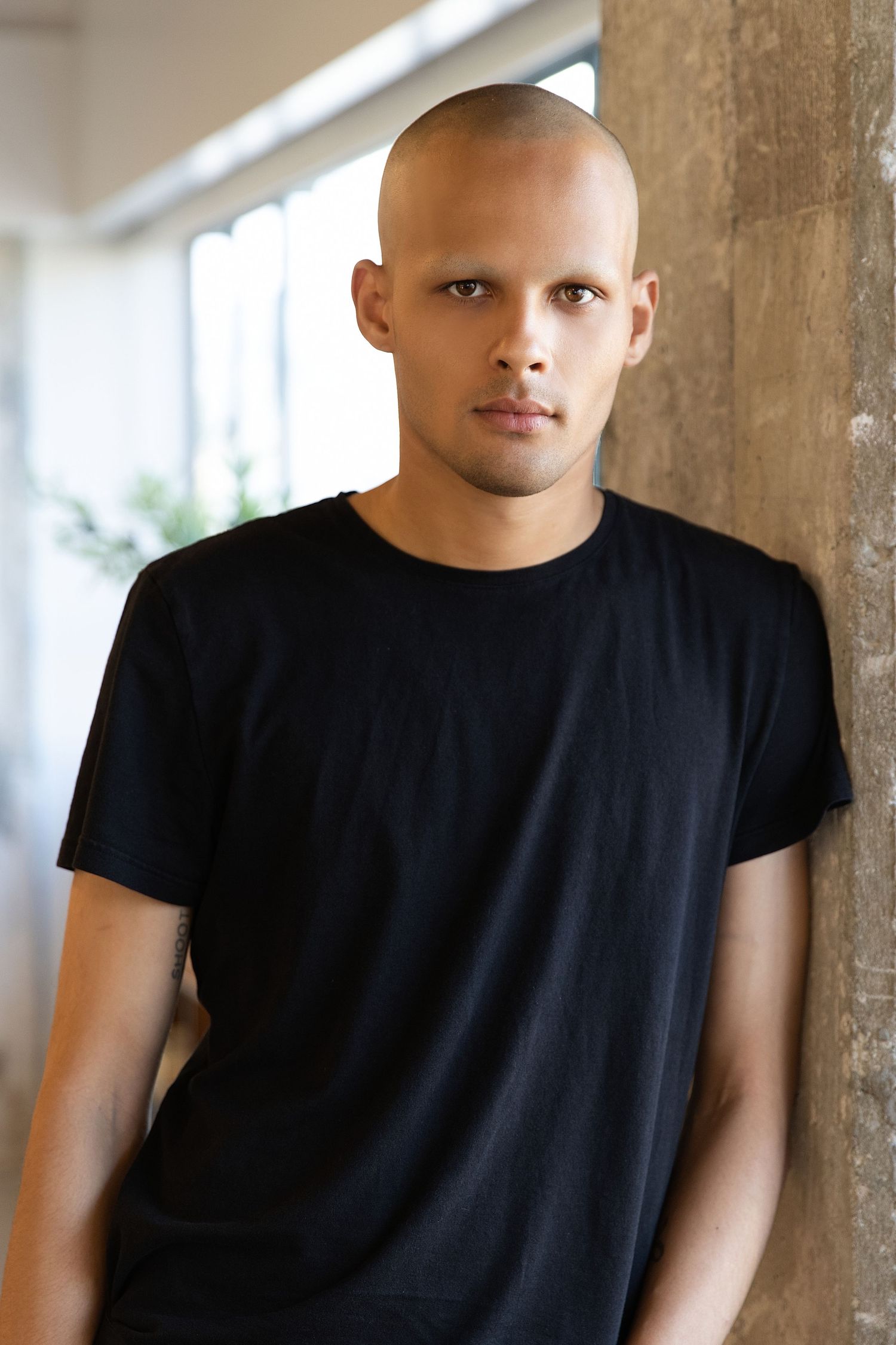 A series of five similar headshots showing a person wearing a black t-shirt against a light background.