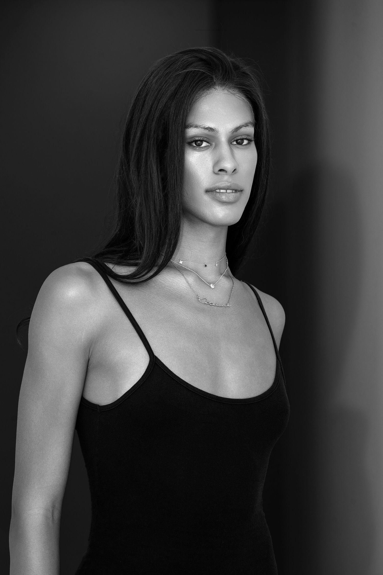 A black and white portrait series showing four progressive views of a woman in a black tank top.