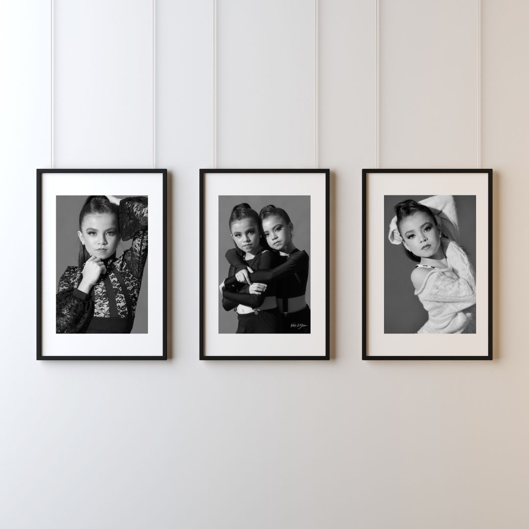Three black and white framed portraits displayed on a white wall in a horizontal arrangement.
