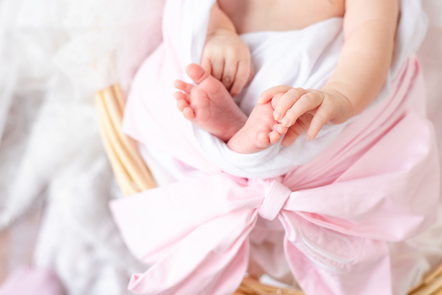 Close-up of baby feet wrapped in pink fabric.