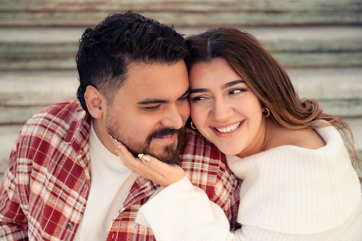 Couple in casual attire sharing intimate moment on stone steps outdoors.