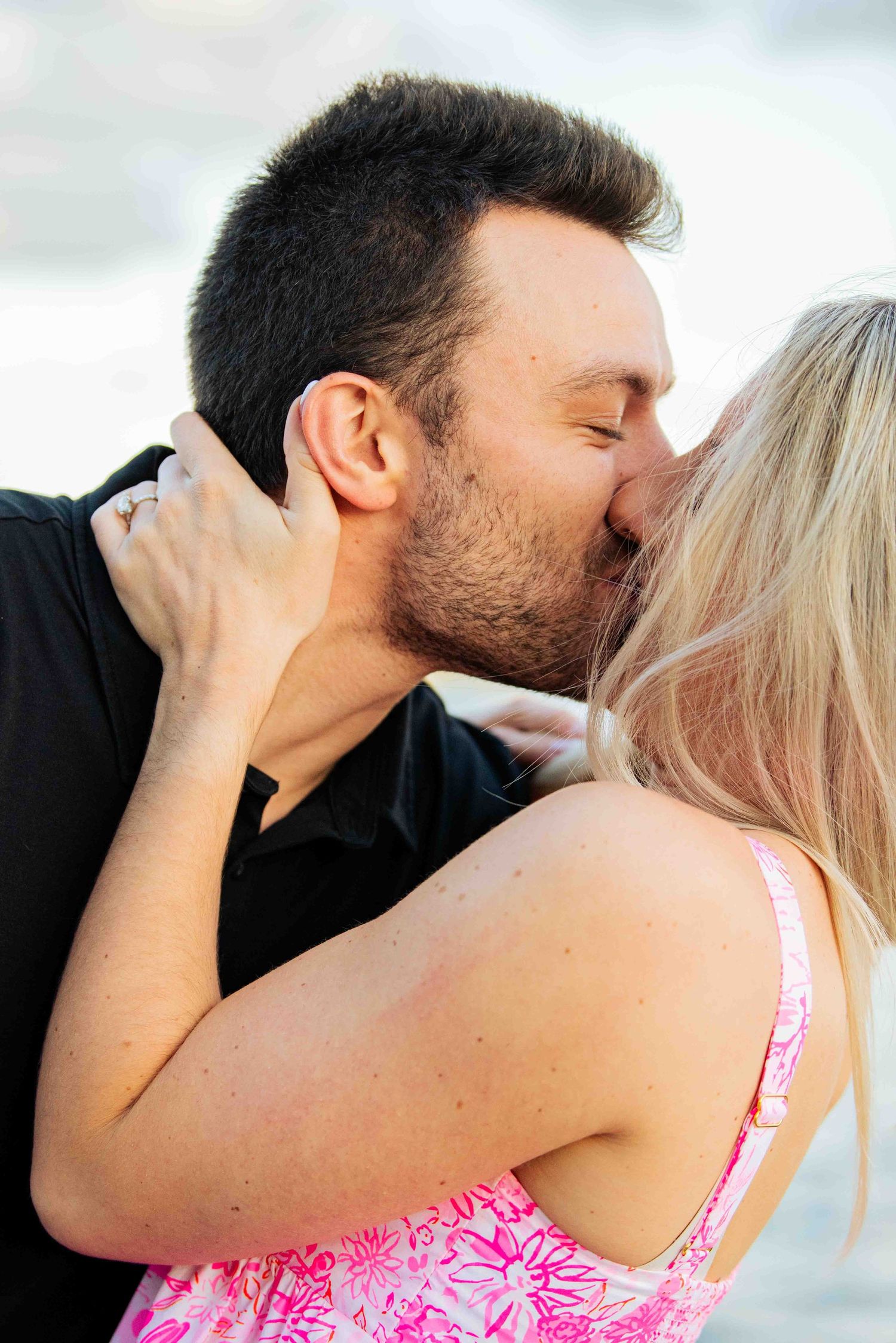 Intimate couple portrait showing tender kiss against soft background.