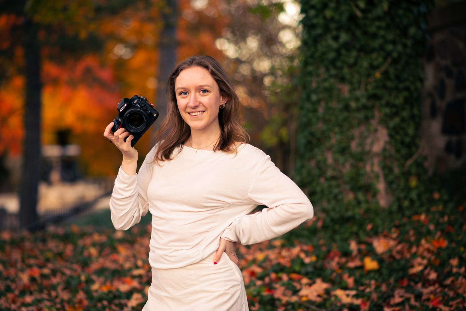Autumn portrait session in park with fallen leaves and natural lighting.
