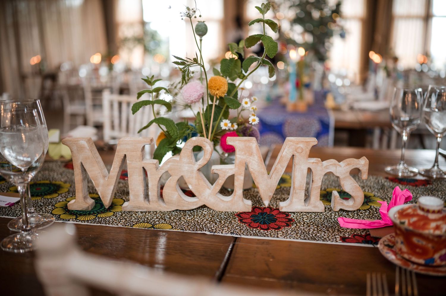 Wedding reception decor featuring Mr & Mrs signage and floral centerpieces.