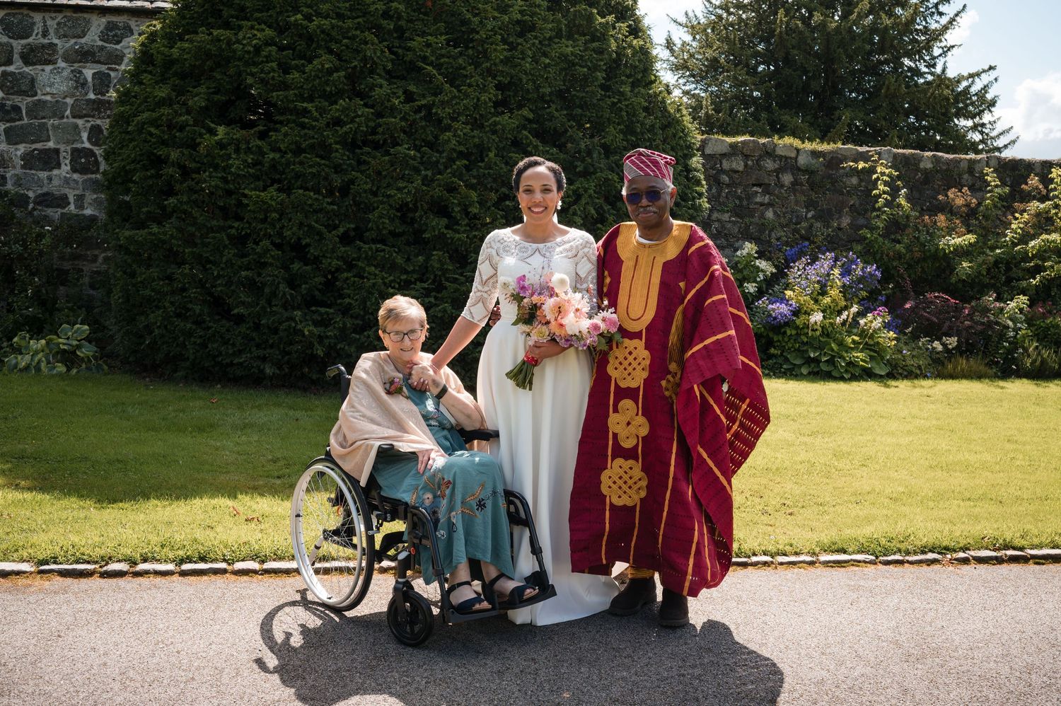 Group gathering in formal attire on a garden pathway.