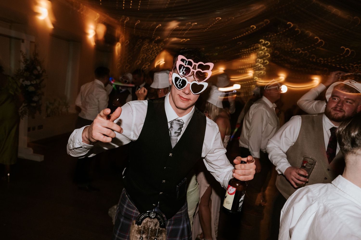 Aberdeen Wedding Photography. Evening wedding reception with guests dancing under warm ambient lighting.