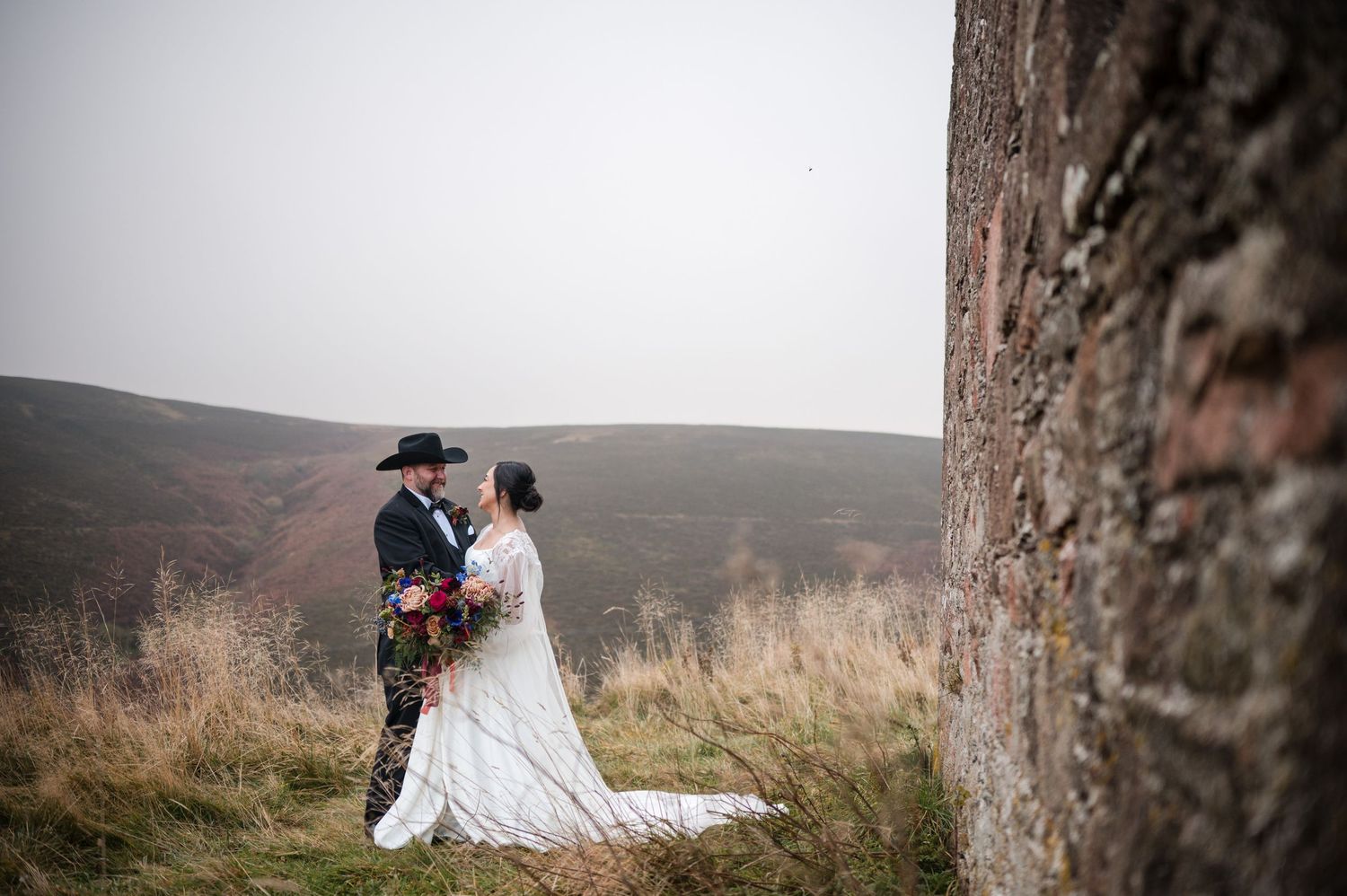 Aberdeen Wedding Photography. A couple walks along a misty mountain path during their wedding photoshoot.