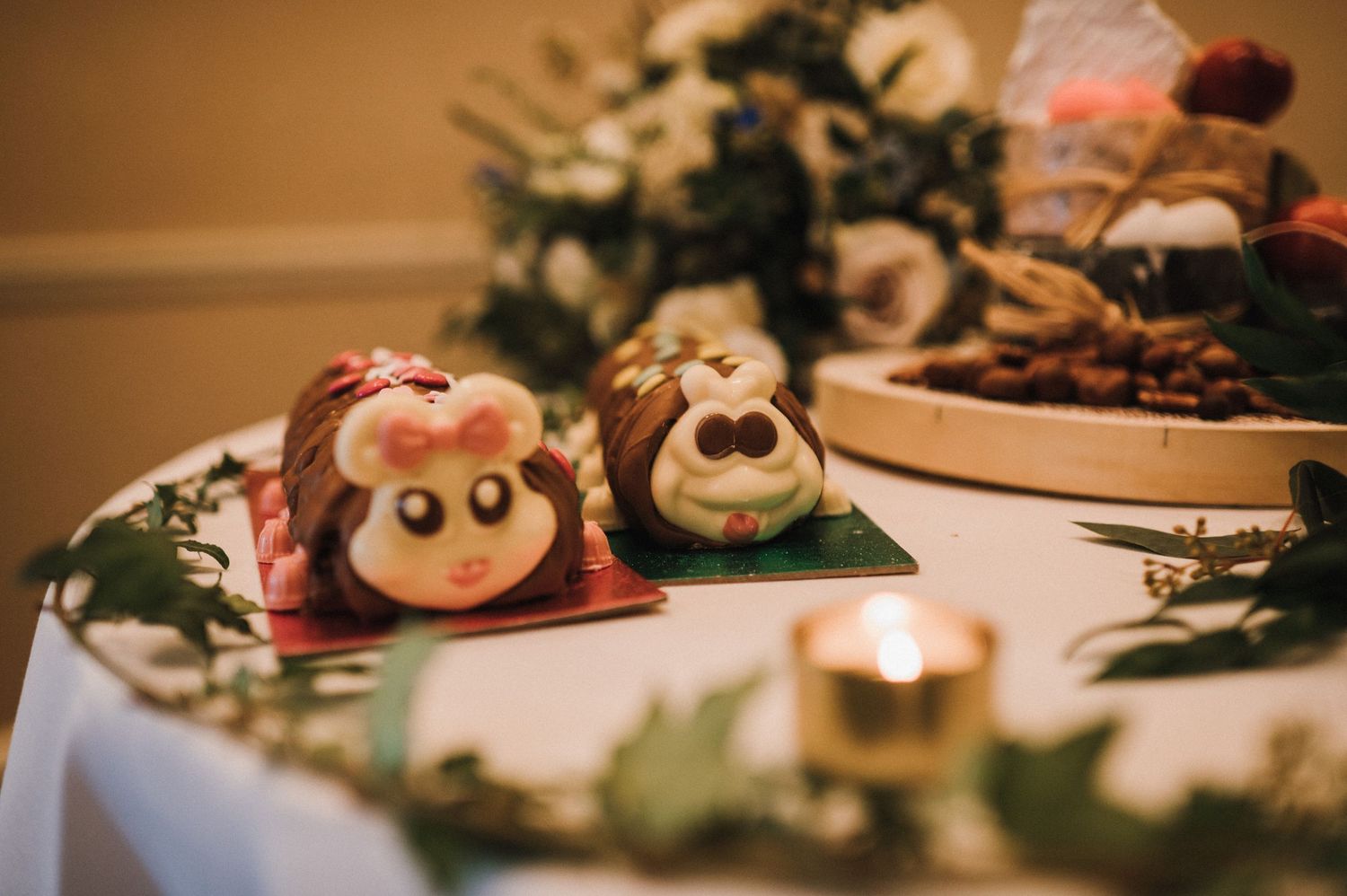 Whimsical animal-themed desserts displayed on white tablecloth at wedding reception.