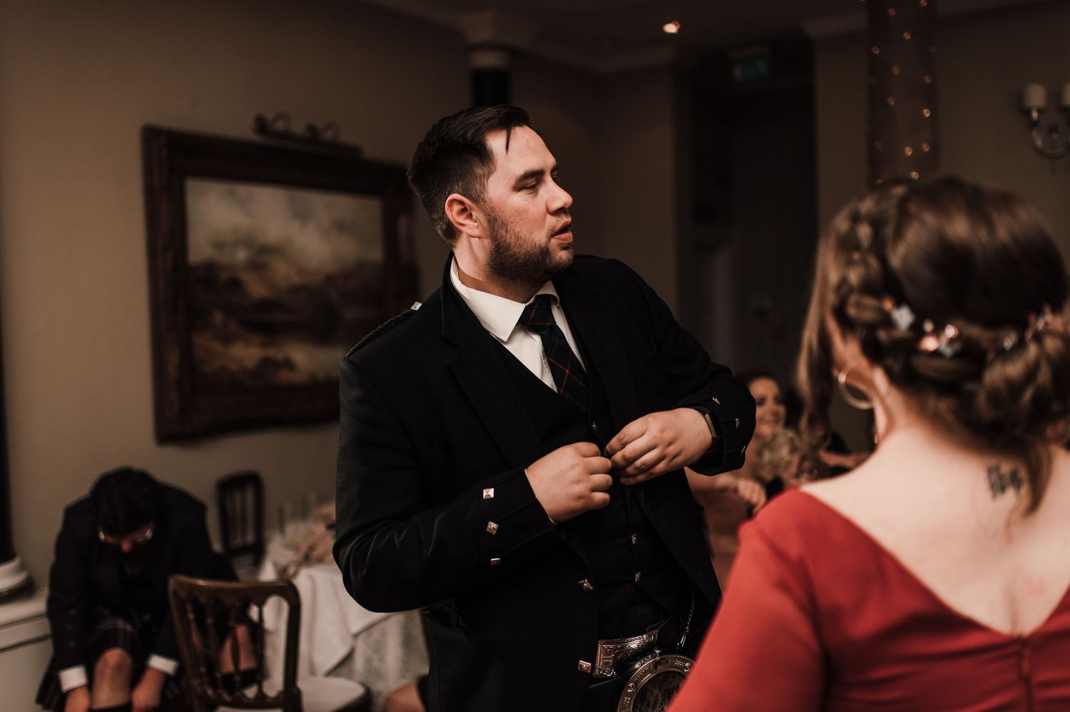 A formal Scottish wedding reception with guests in traditional formal wear.