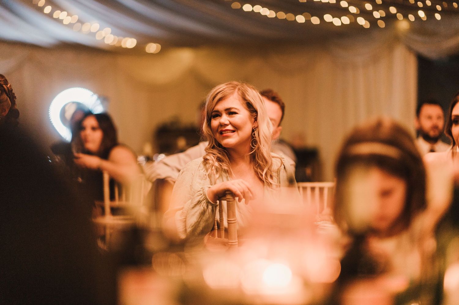 Candid reception moment captured in warm lighting with guests celebrating.
