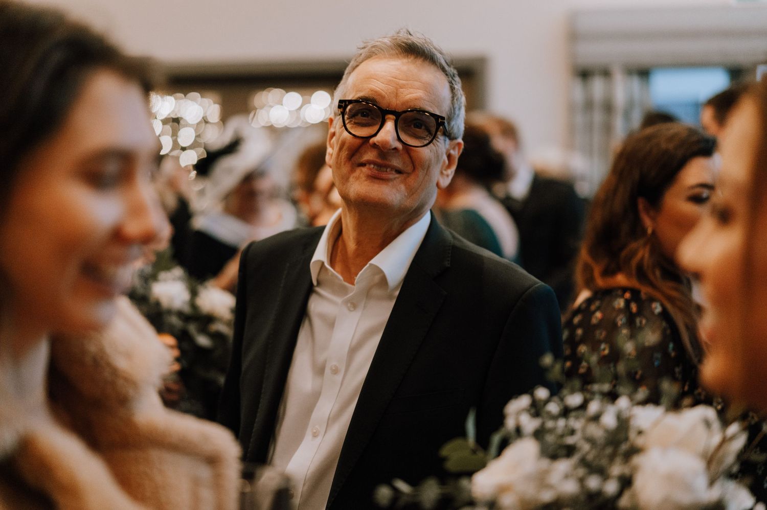 Candid moment of wedding guests smiling and enjoying the celebration.