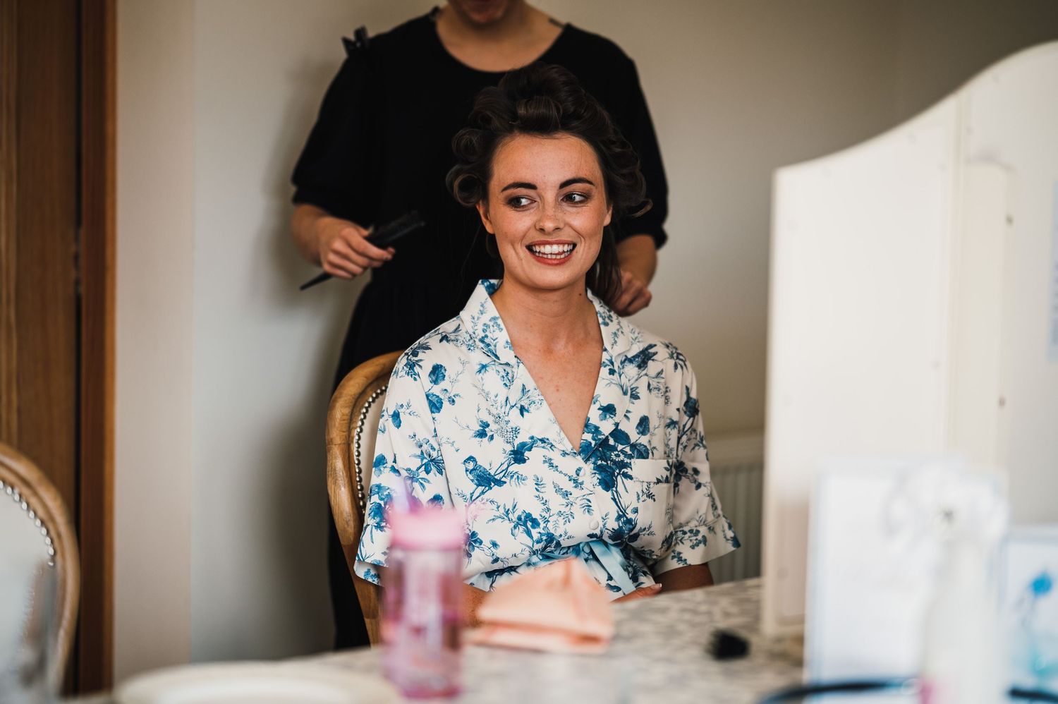Morning wedding preparations with blue floral robe in natural lighting.