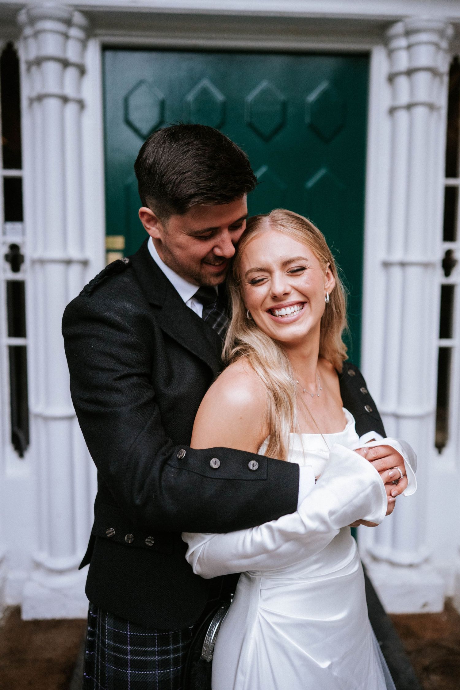 Couple shares romantic moment in traditional Scottish wedding attire.