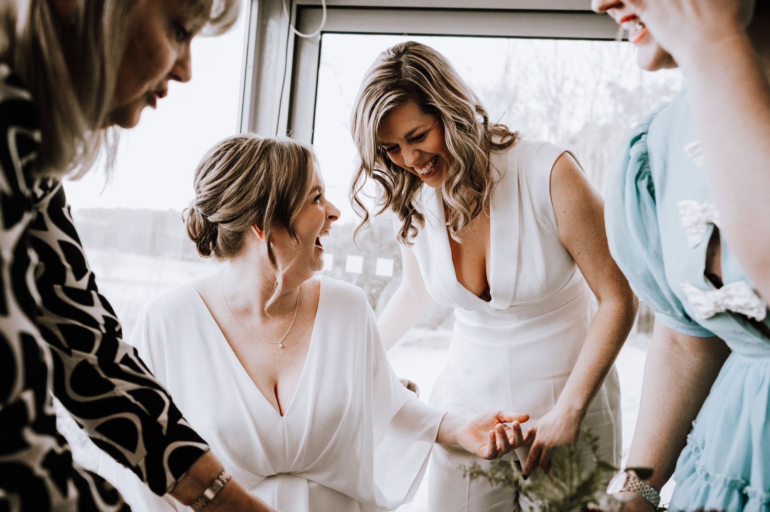 Same Sex Wedding Photography. Wedding party members share an intimate moment while getting ready in white robes.