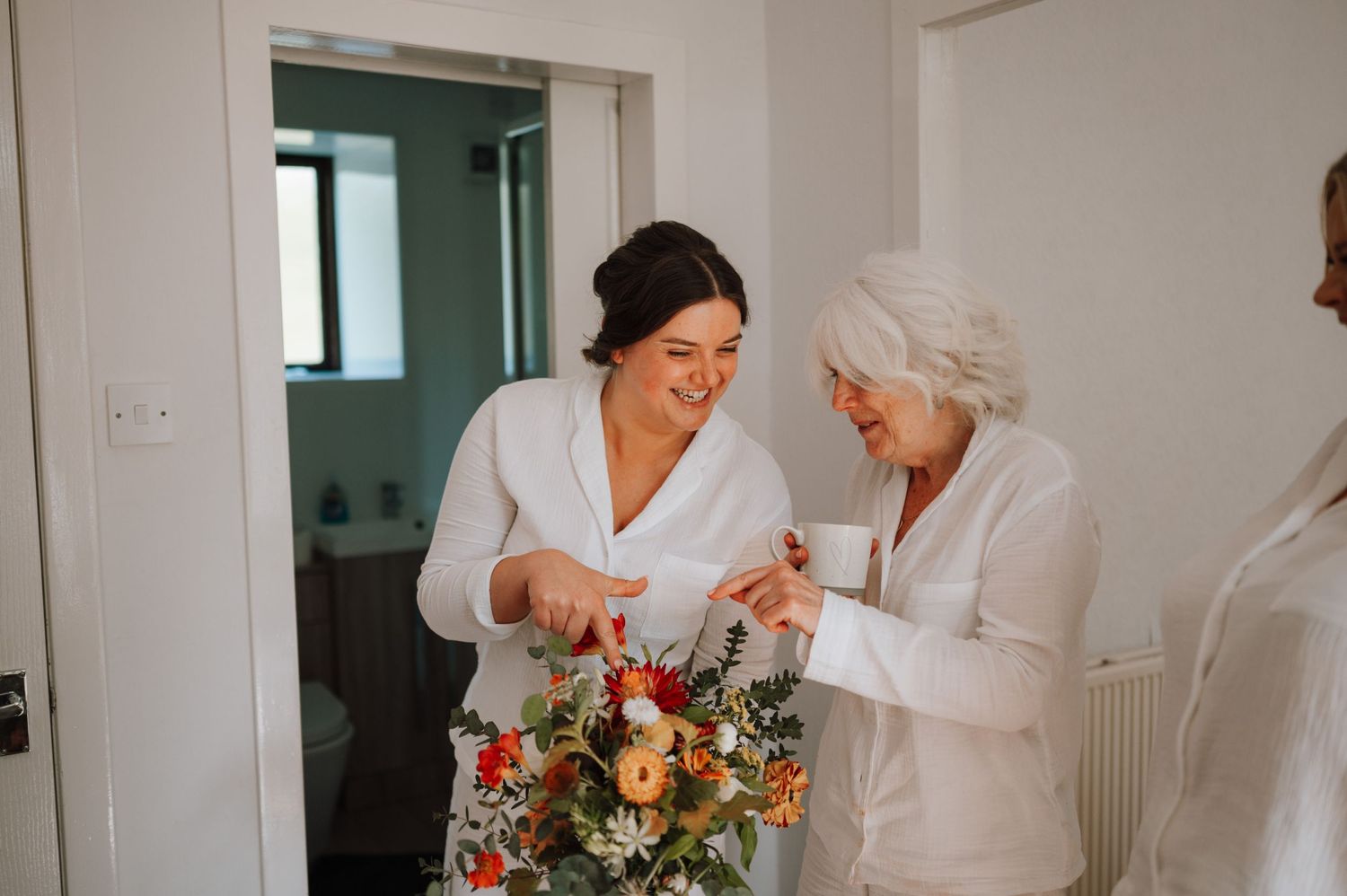 Two people admiring a colorful floral arrangement in a bright indoor setting.