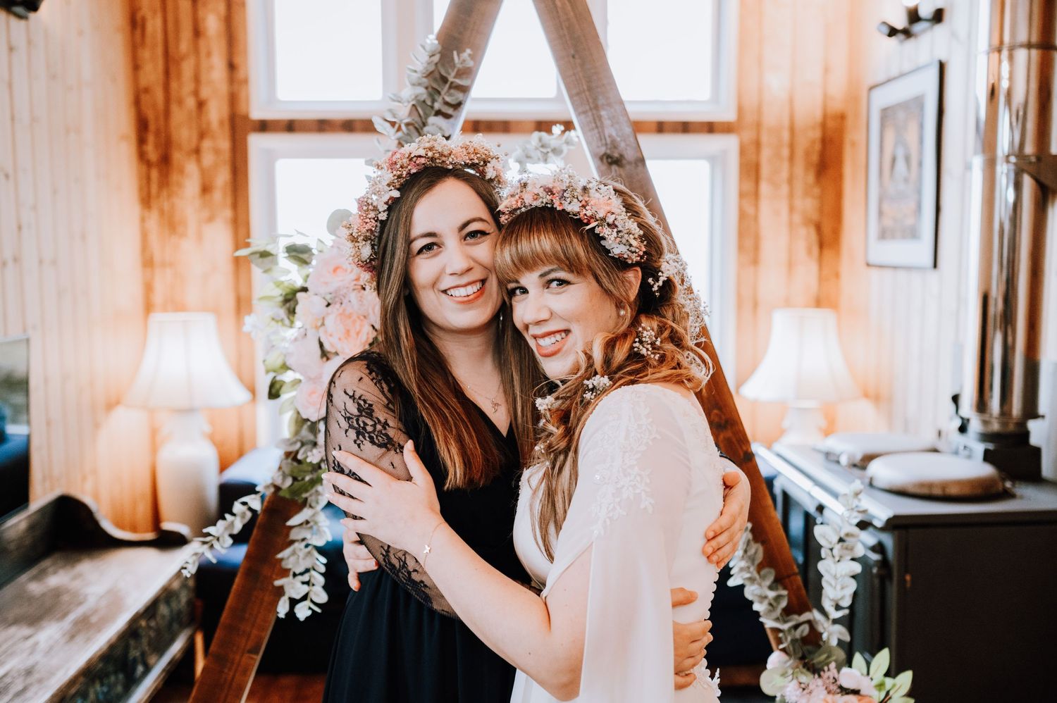Wedding celebration in rustic chapel with decorative A-frame and natural lighting.