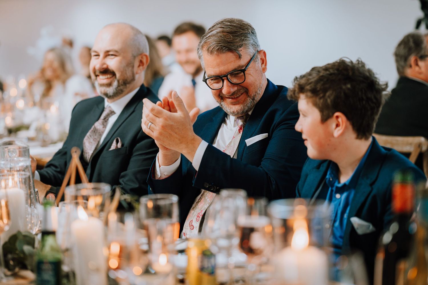 Wedding guests sharing a lighthearted moment at the reception dinner table.