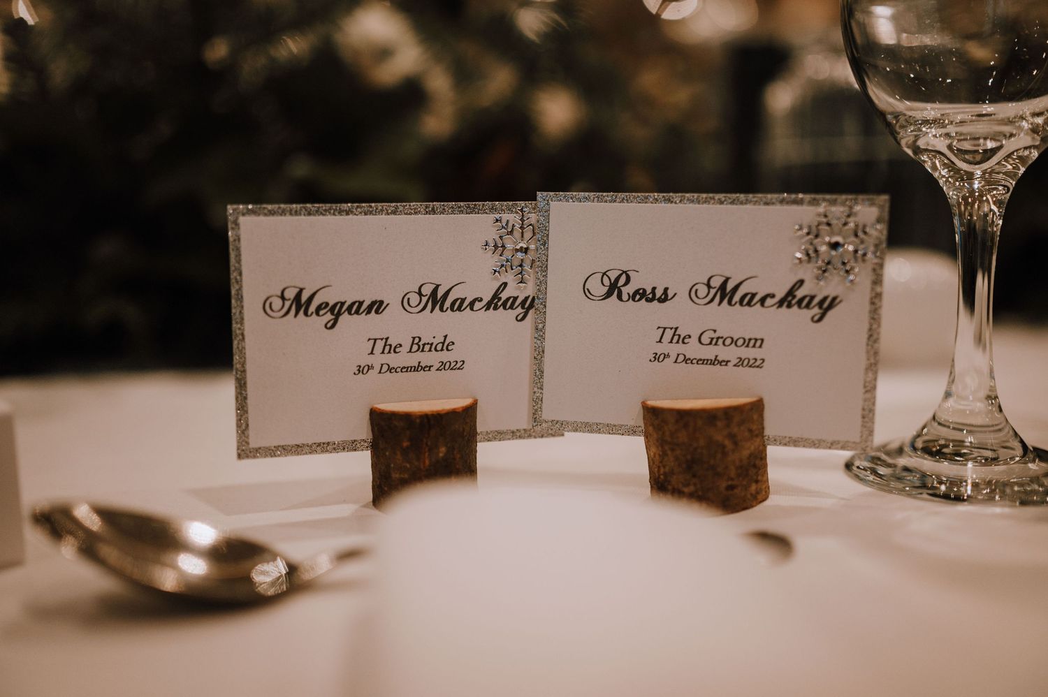 Wedding place cards displayed on cork holders at formal table setting.