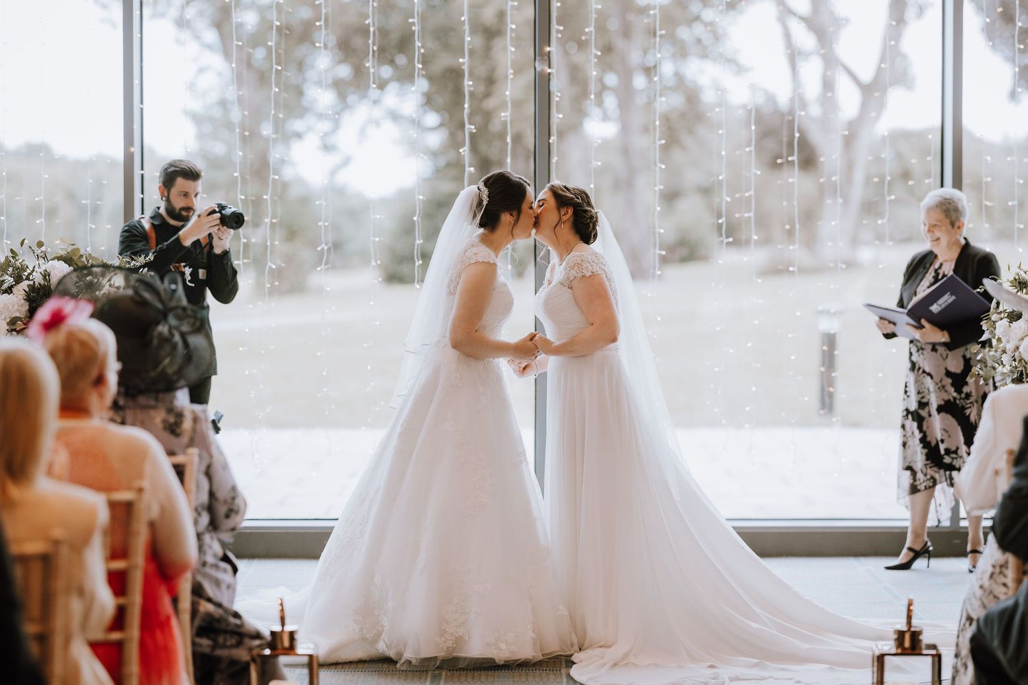 Wedding celebration in bright venue with large windows overlooking natural scenery. Meldrum House Wedding Photography.