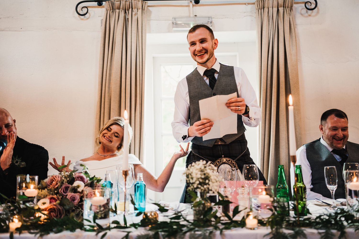 Wedding reception dinner candid moments captured in elegant indoor venue setting.