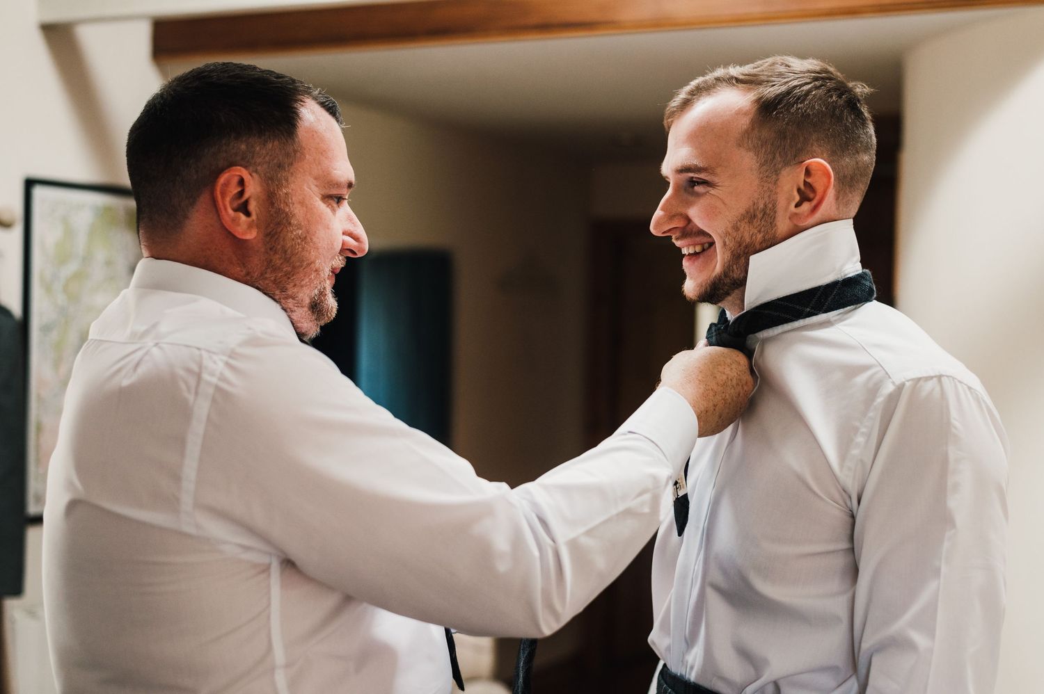 Two people wearing white shirts embrace warmly while sharing a joyful moment together.