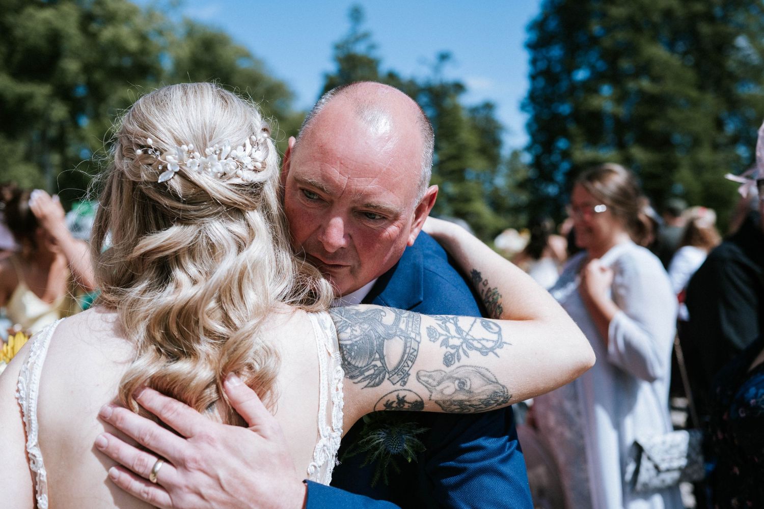 Emotional wedding moments shared between guests during outdoor summer ceremony.