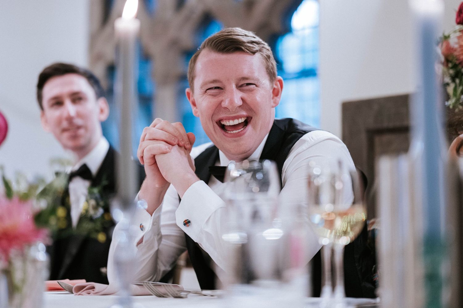 Candid moments captured during wedding speeches at an elegant indoor reception.