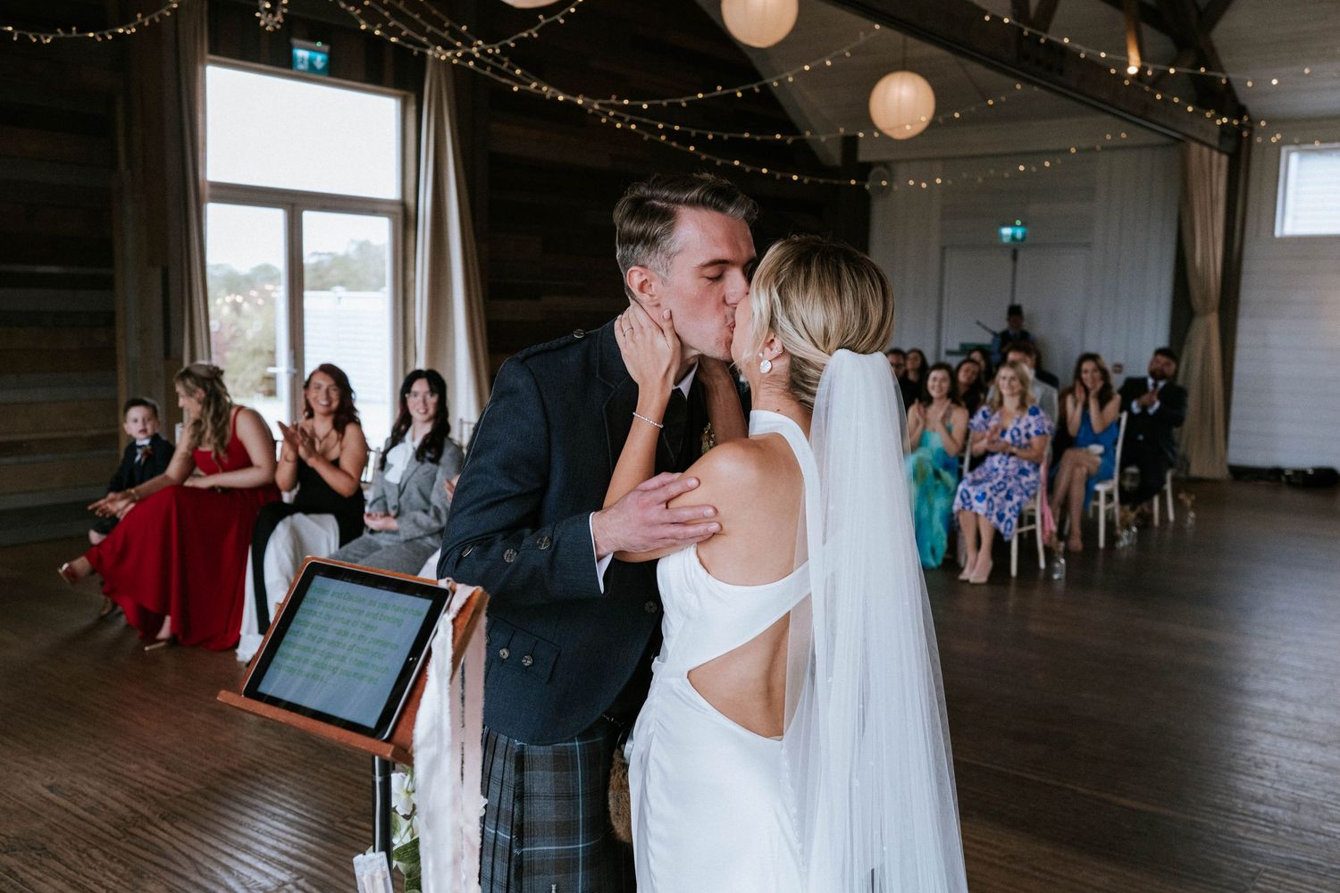 Wedding ceremony moments captured in a rustic indoor venue with romantic lighting.