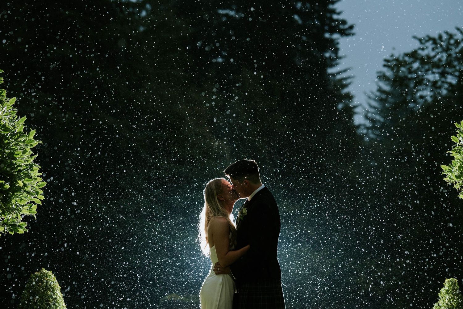 Silhouetted couple shares an intimate moment against a starlit night sky.