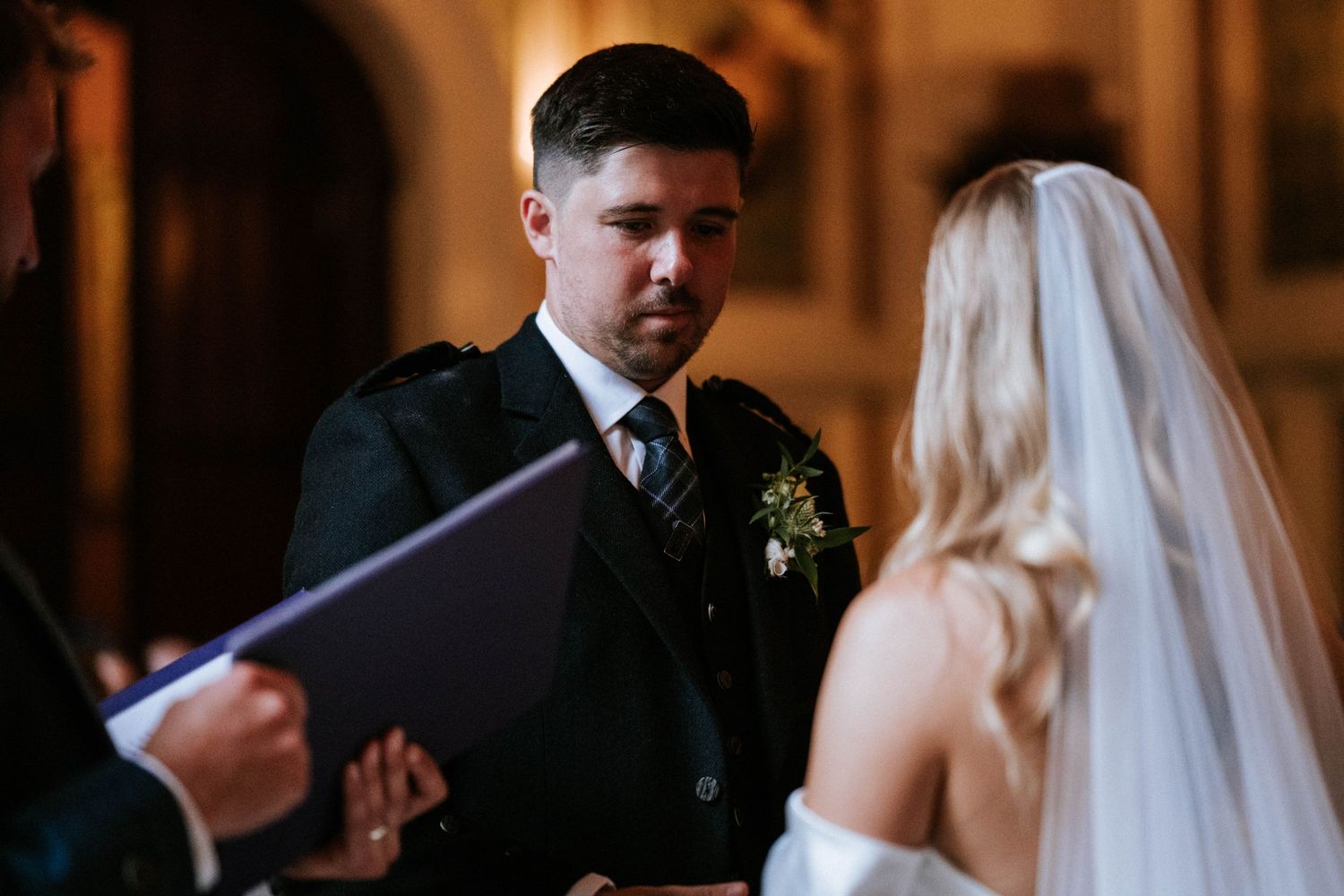 Intimate wedding ceremony moment captured in warm lighting with romantic ambiance.