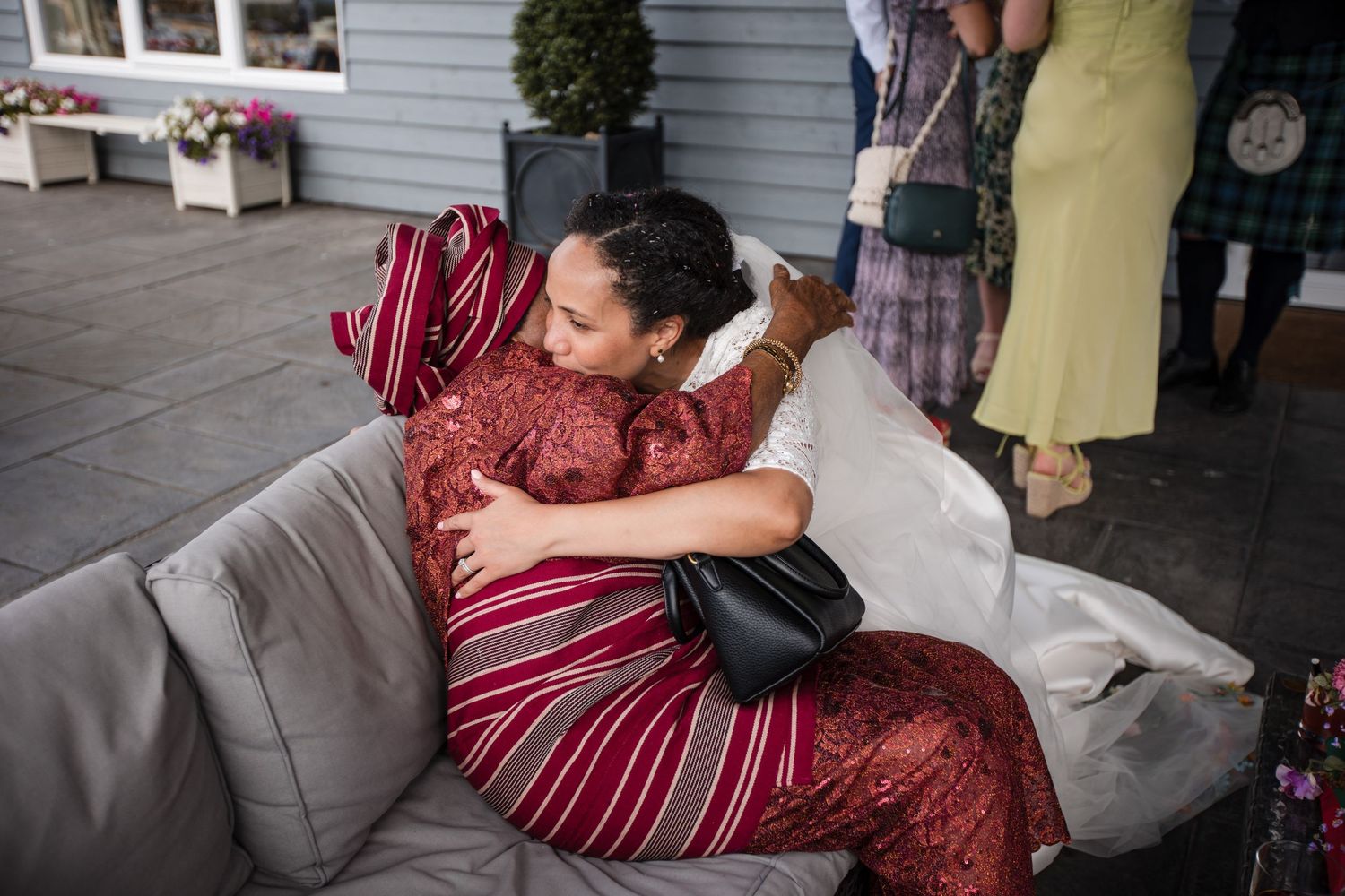 Candid moments of wedding guests sharing embraces at an outdoor reception.