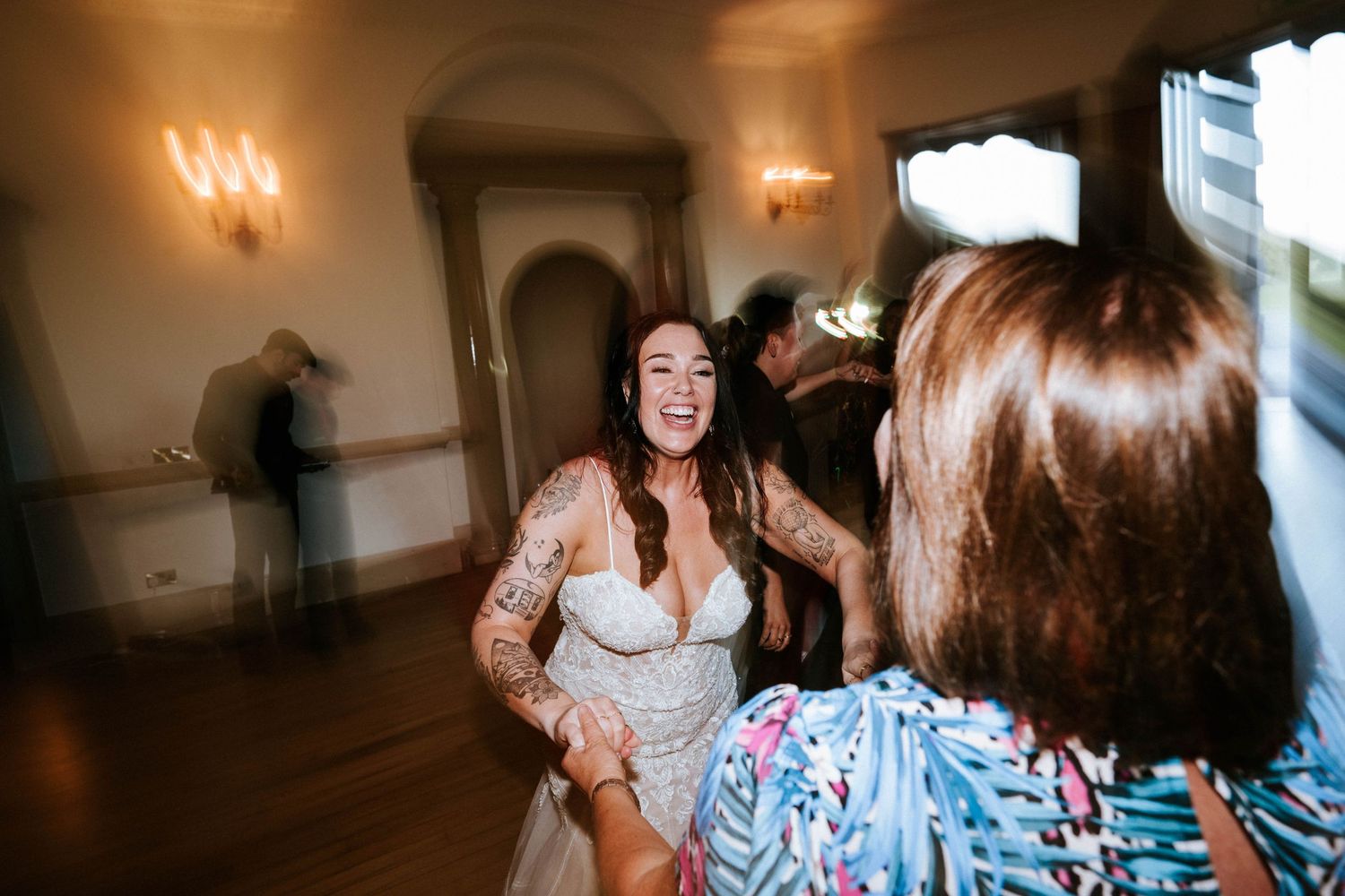 Aberdeen Wedding Photography. Wedding reception guests dancing and celebrating in an indoor venue with warm lighting.