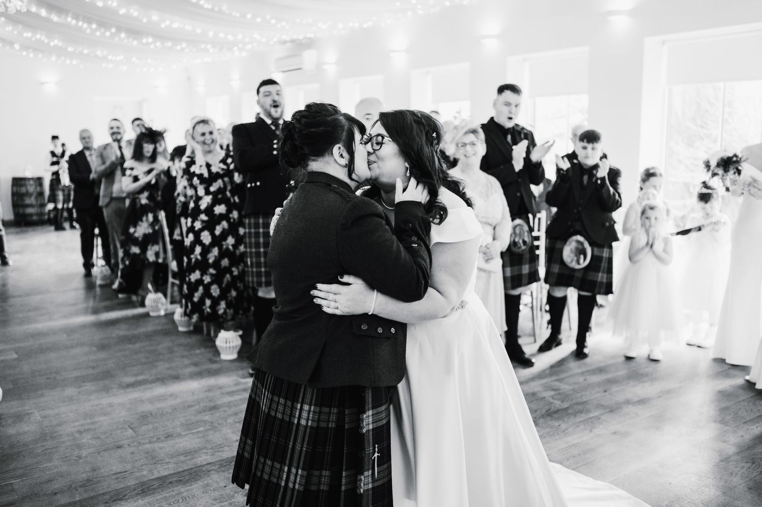 Logie House Wedding Photography. Black and white photo of wedding guests celebrating at a reception.