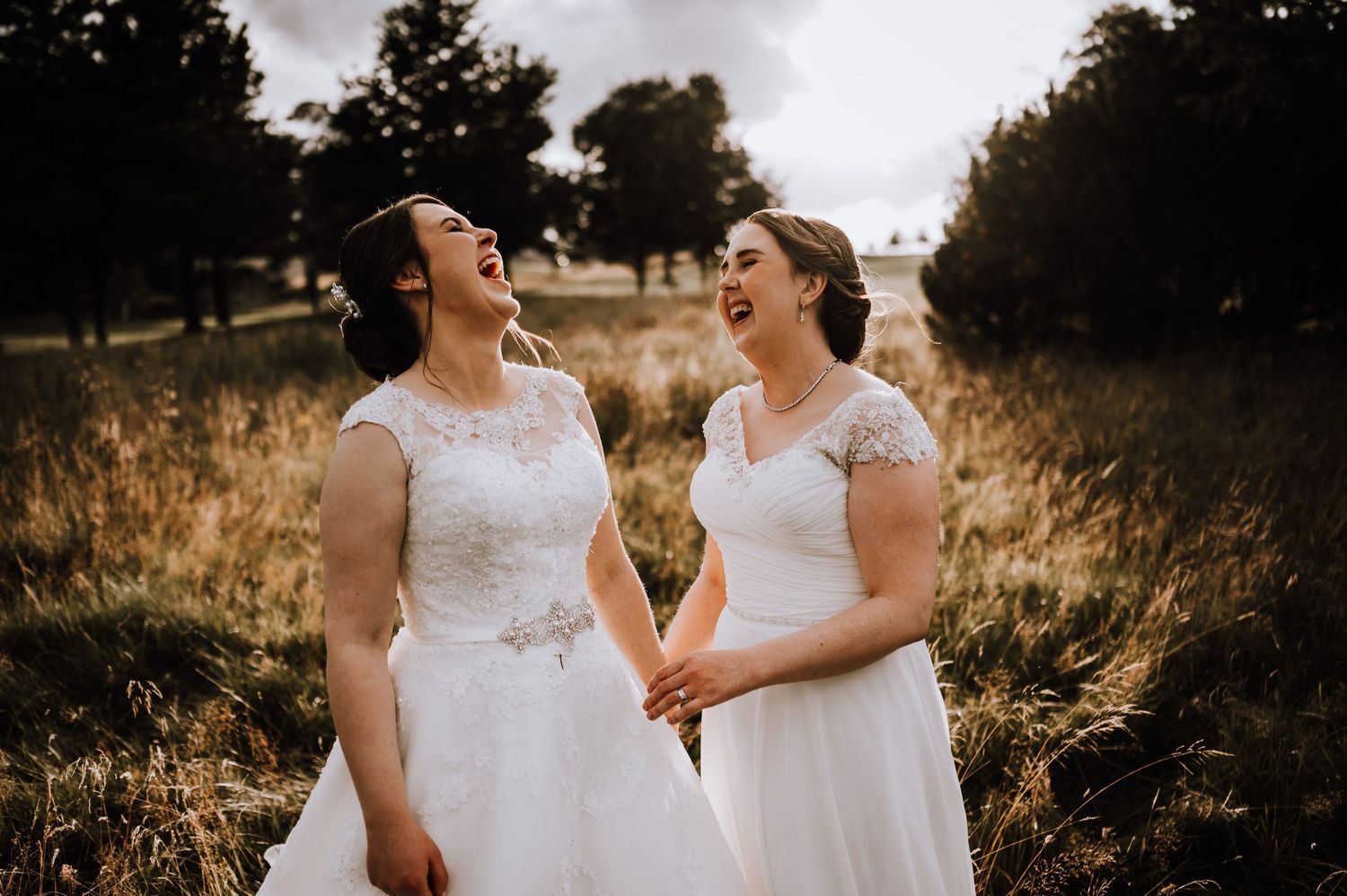 Aberdeen Wedding Photography. Joyful wedding couple shares laughter in a sun-drenched field.