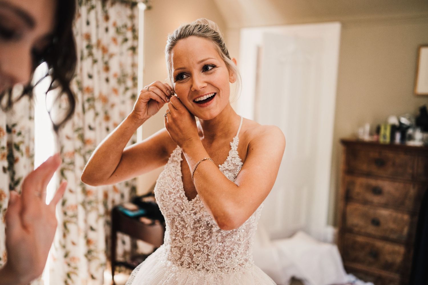 Emotional moment captured during final wedding preparations in a sunlit room.