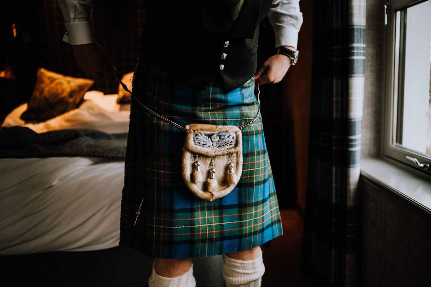Close-up of a blue and green tartan kilt with sporran detail.