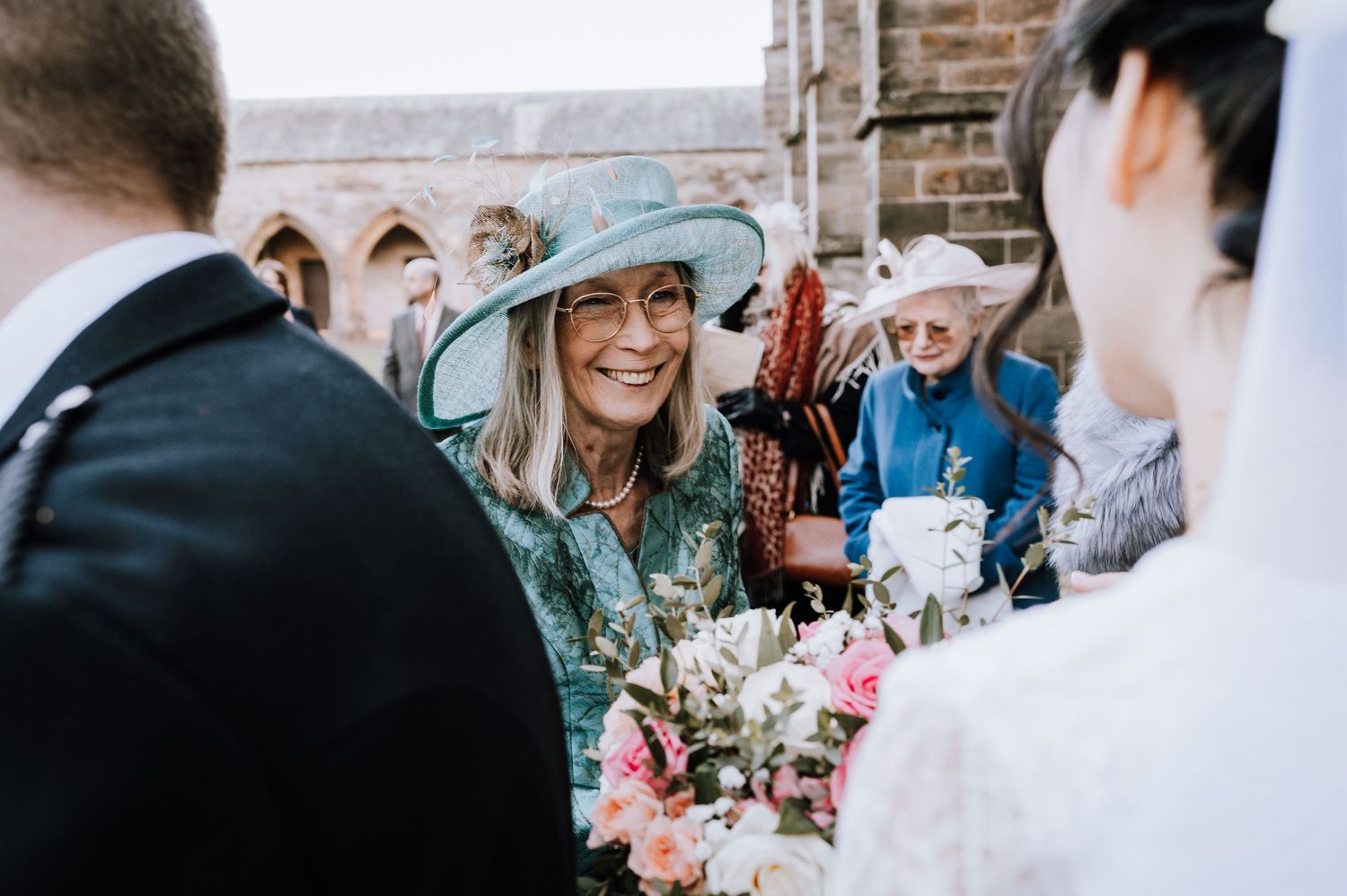 Wedding guests chatting and celebrating at an outdoor church reception.