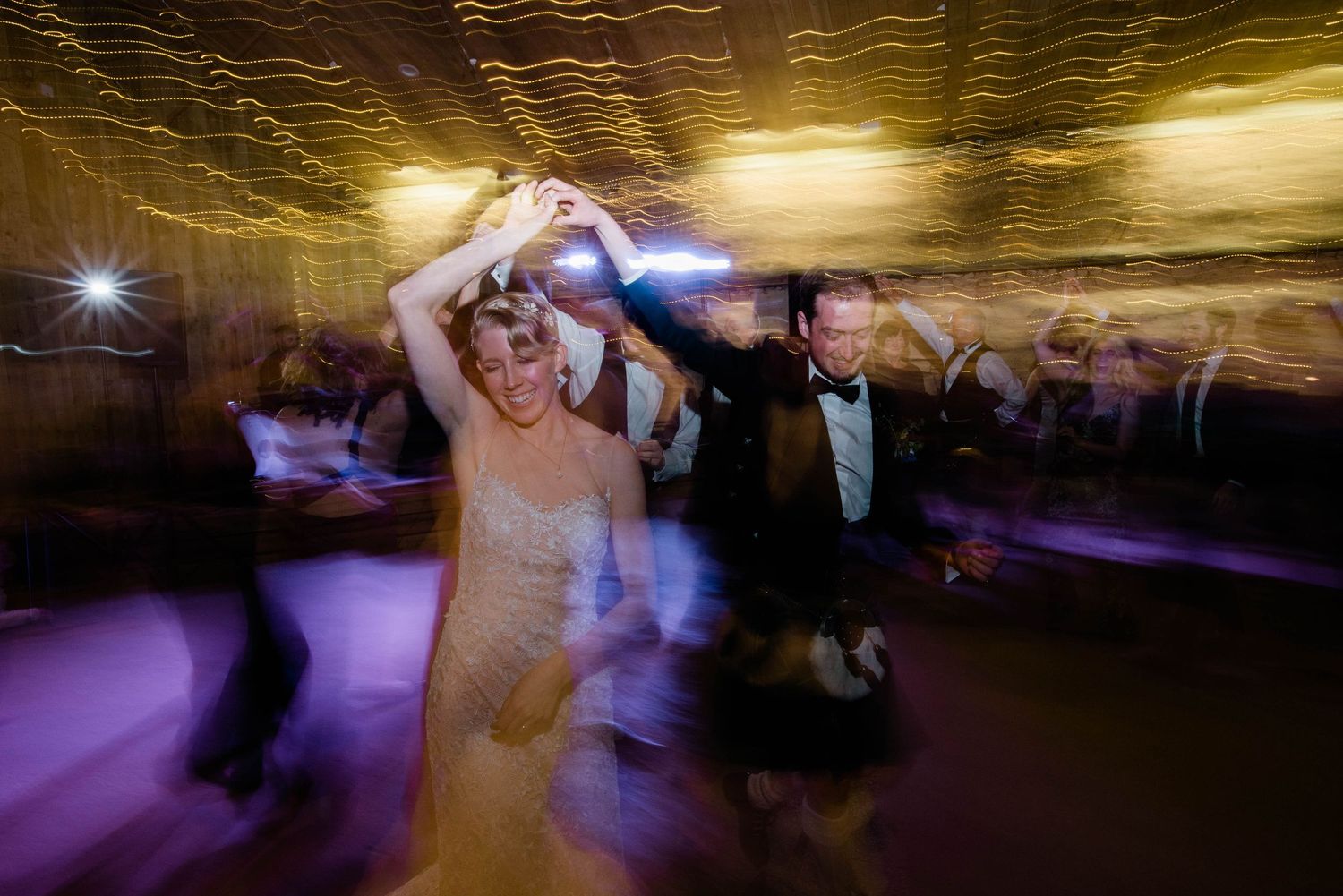 Wedding celebration captured with motion blur creates a dreamy dancing atmosphere.