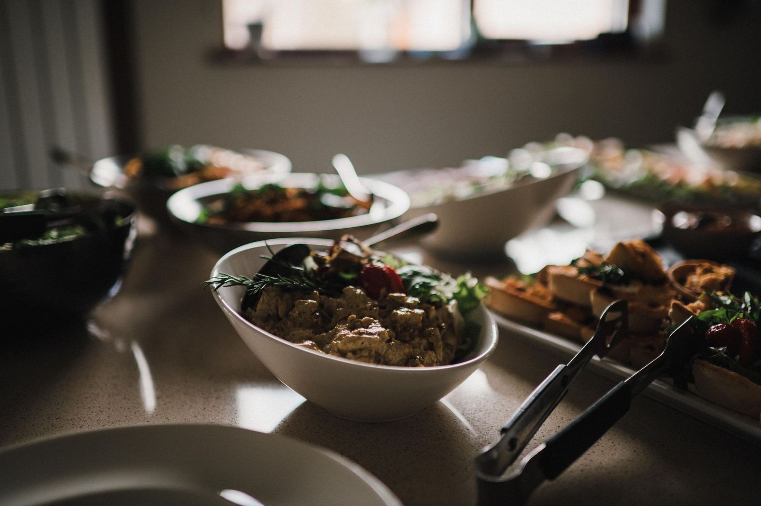 Close-up of hearty stew or braised meat dish garnished with fresh herbs in white bowl.
