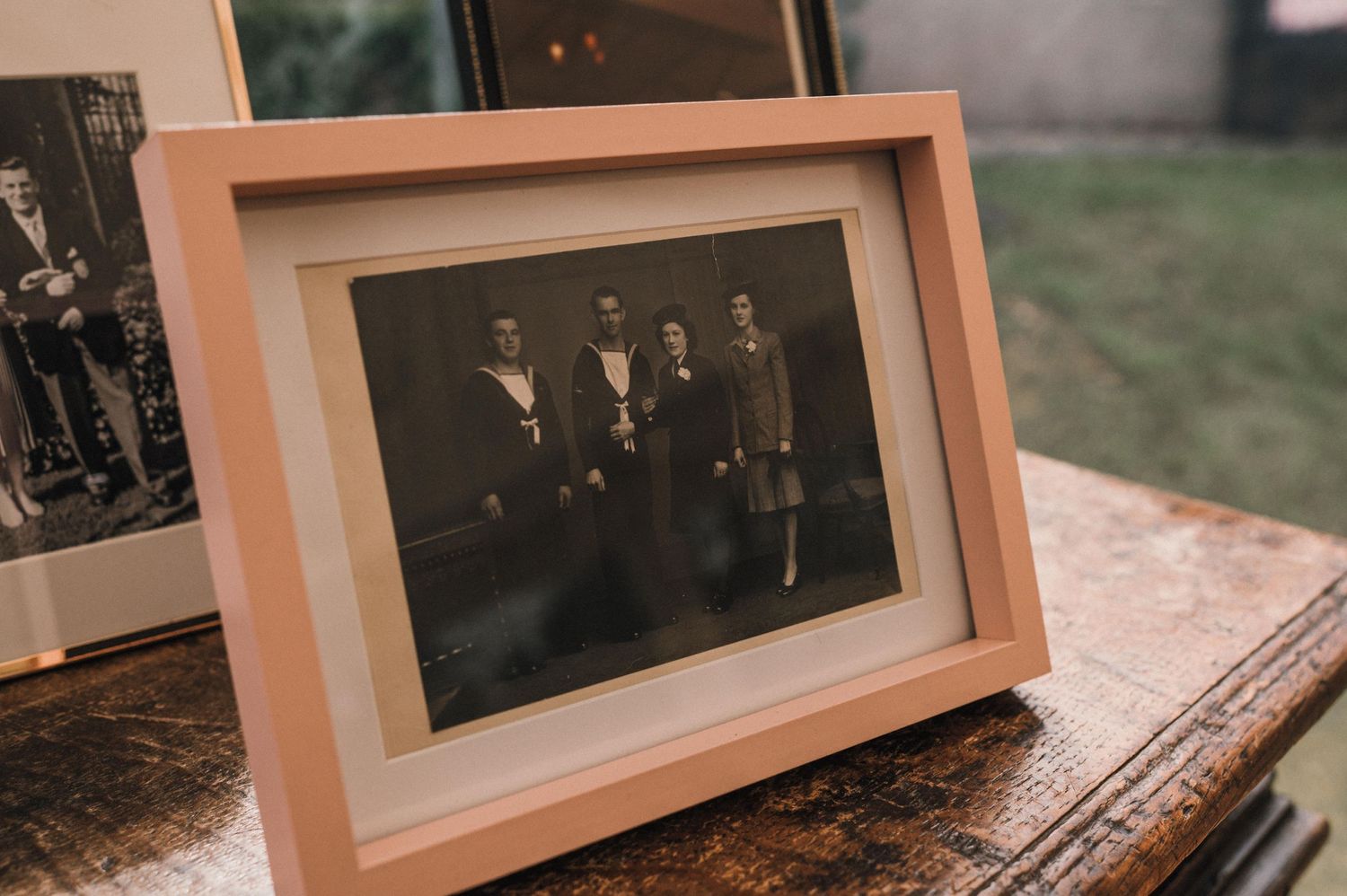 An old black and white photograph in a light wooden frame.