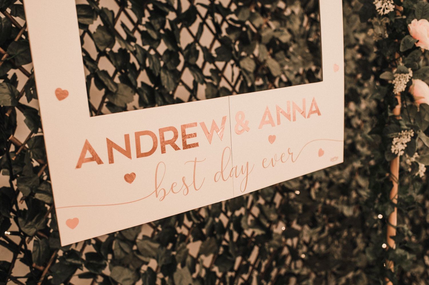 Wedding signage with names against textured background in warm tones.