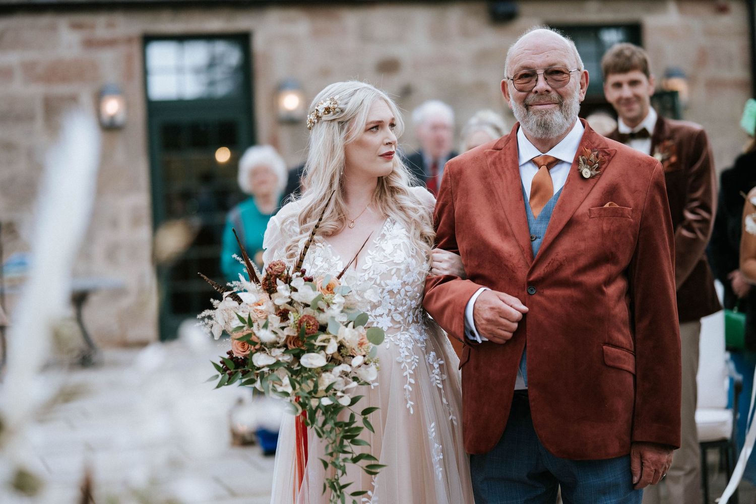 Elegant wedding ceremony moments captured in a rustic stone venue with warm autumn tones and floral arrangements.