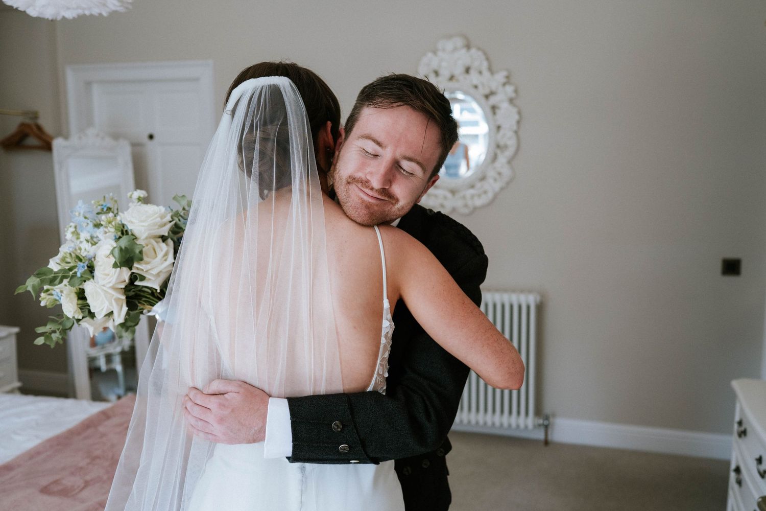 Emotional first look moment between couple in white wedding attire.