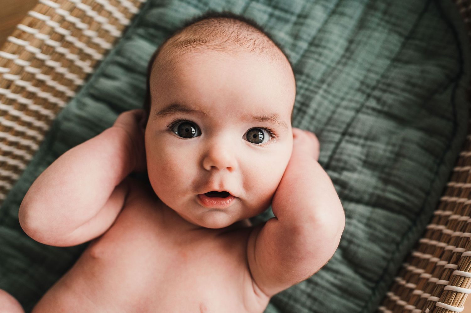Close-up view of a baby lying on a textured surface with a soft, dreamy atmosphere.