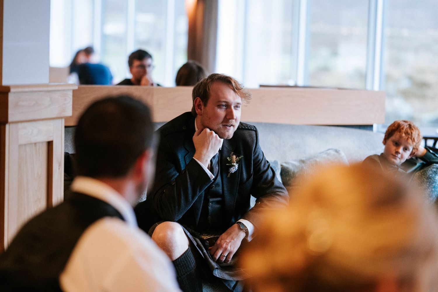 Guests mingle and socialize at a reception venue with warm lighting and stone walls.