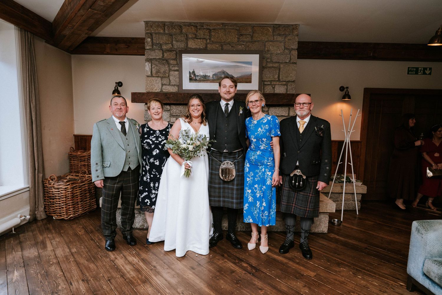 Wedding reception venue interior with rustic stone walls and wooden beams decorated for celebration.